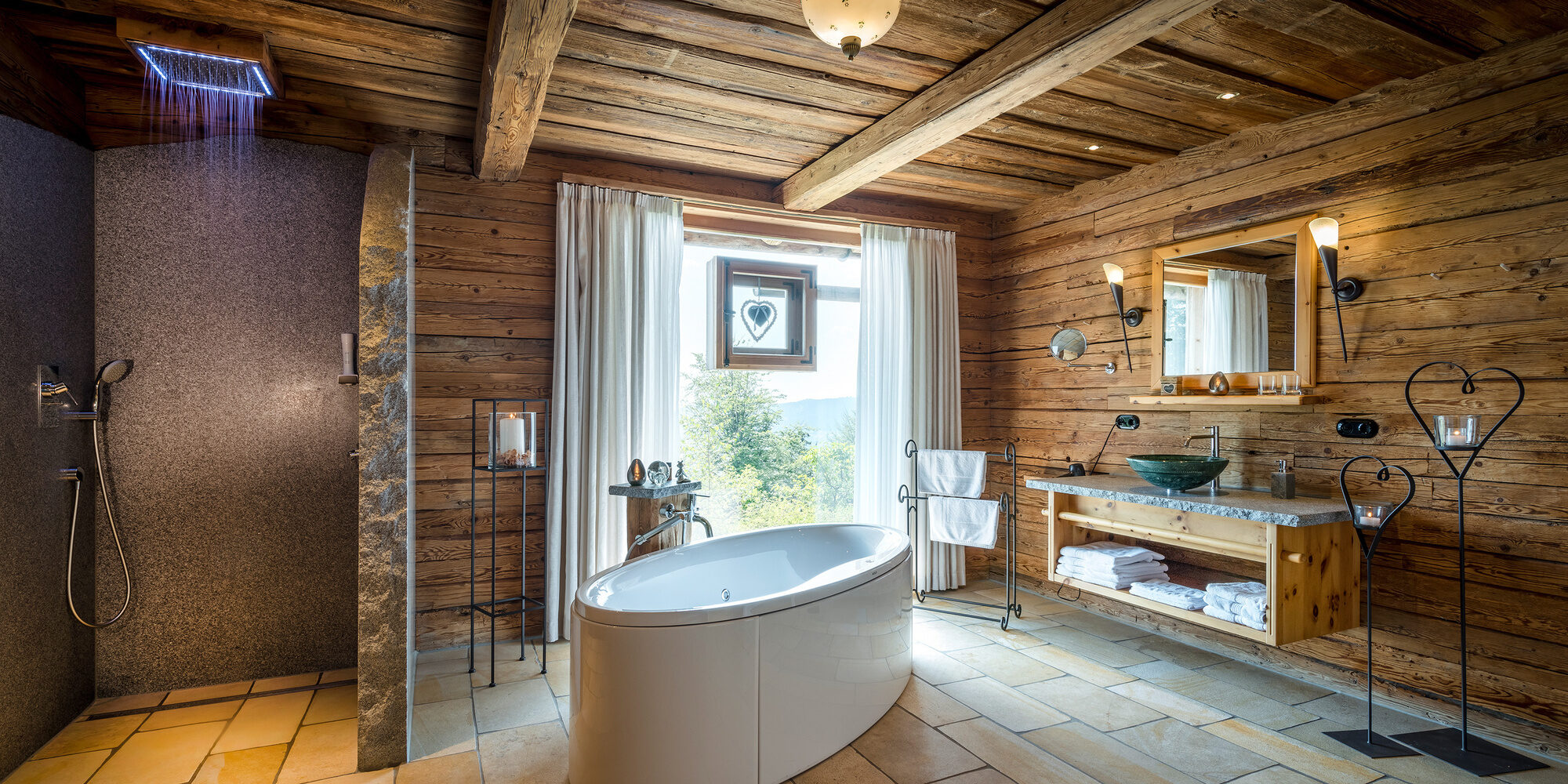 Badezimmer im Luxus Chalet Bayern mit freistehender Badewanne und Panoramafenster
