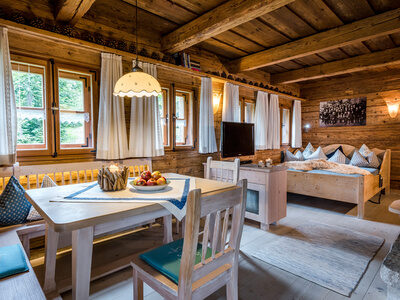 Wohnbereich mit Esstisch und Bett im Luxus Chalet Bayern im Bergdorf Hüttenhof