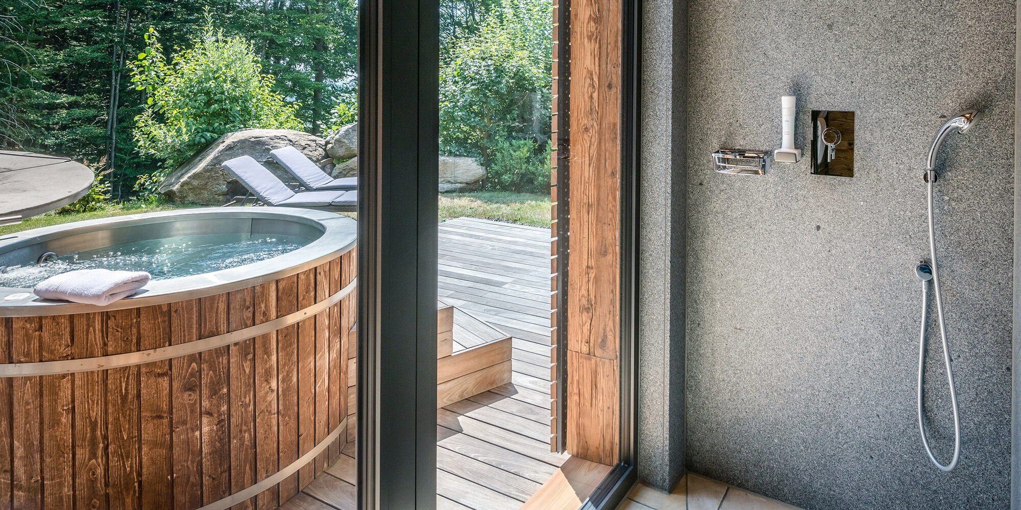 Dusche mit Blick auf die Terrasse mit Whirlpool des Luxus Chalets Bayern
