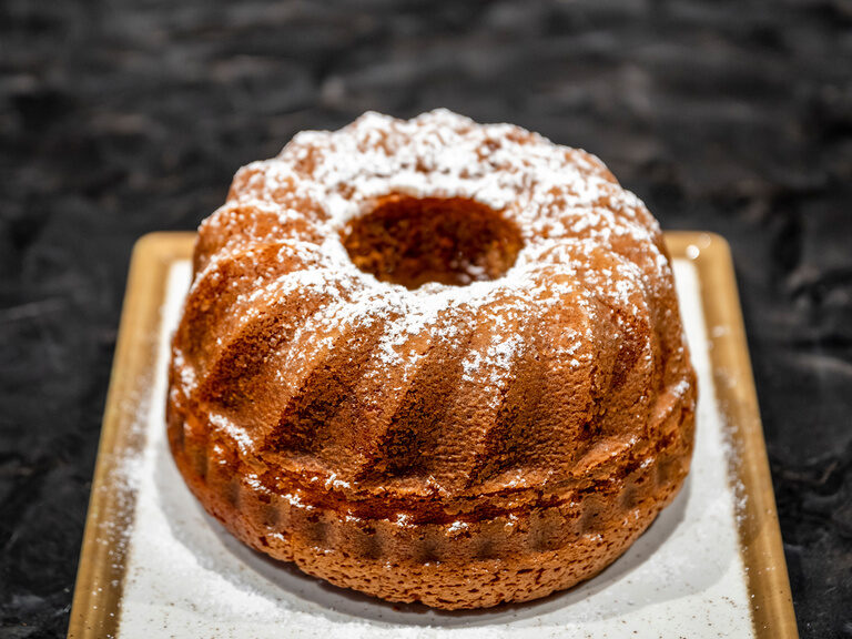 Modern gestalteter Raum mit Sitzbank für Aroma-Dampfbad, beleuchtet in warmen Rottönen