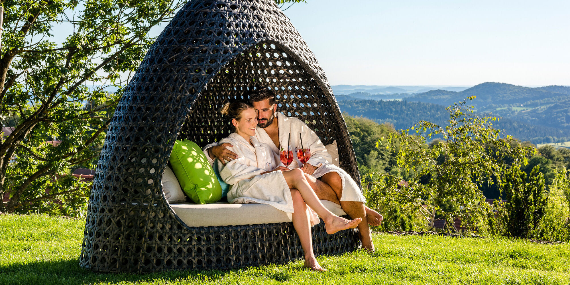 Pärchen genießt Cocktail im Außenbereich des Wellnesshotels Hüttenhof Bayerischer Wald