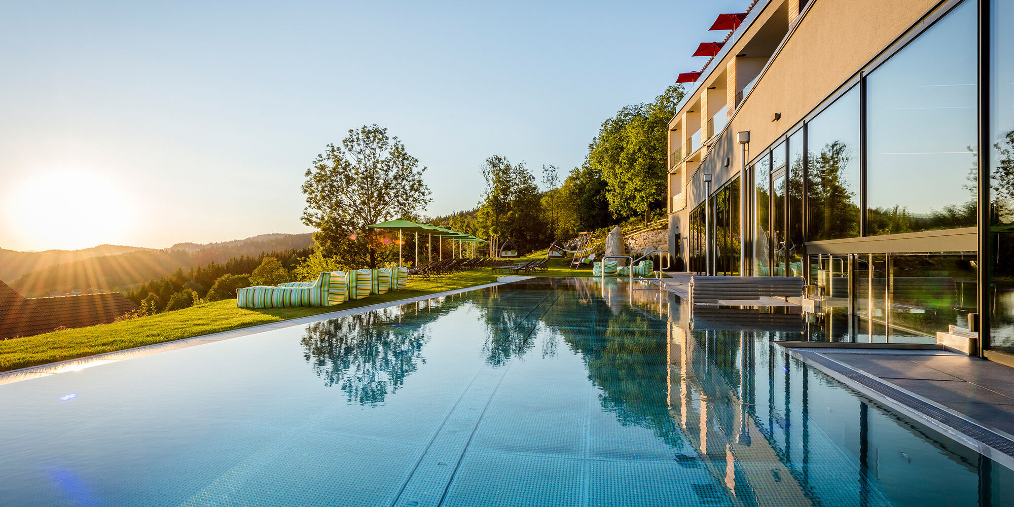 Hotel Hüttenhof mit Außenpool und Panorama bei Sonnenuntergang