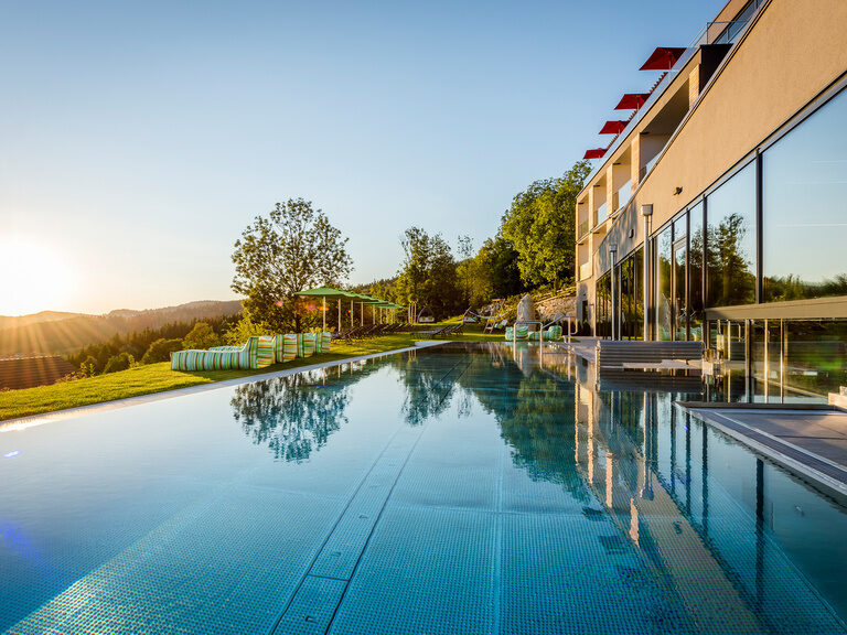 Hotel Hüttenhof mit Außenpool und Panorama bei Sonnenuntergang