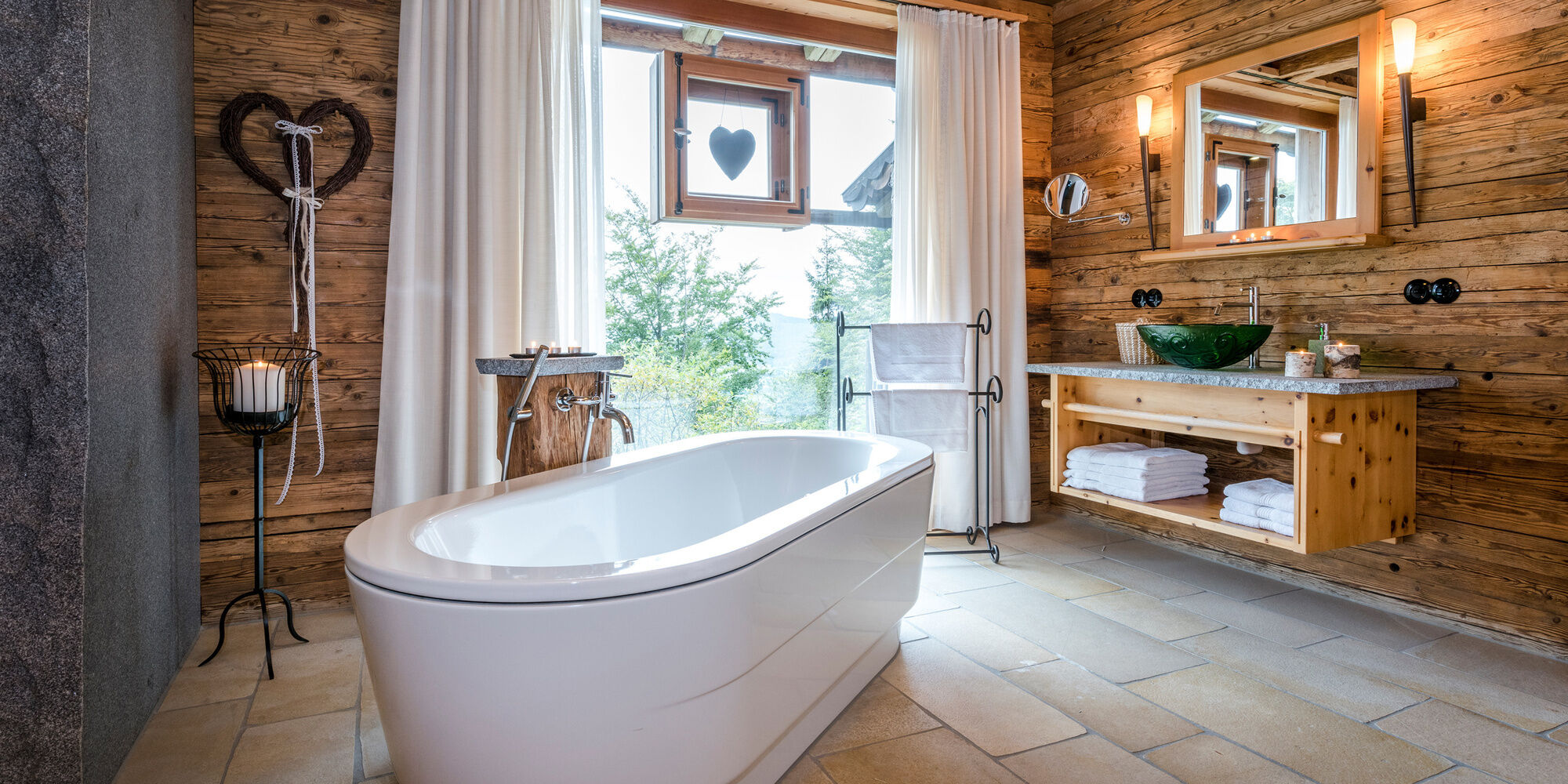 Freistehende Badewanne mit großem Fenster im Luxus Chalet Bayern