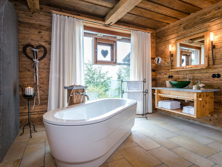Freistehende Badewanne mit großem Fenster im Luxus Chalet Bayern