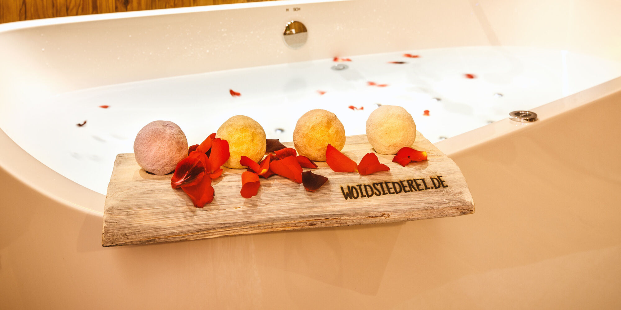 Badewanne mit Badekugeln und Rösenblätter im Luxus Chalet Bayerischer Wald