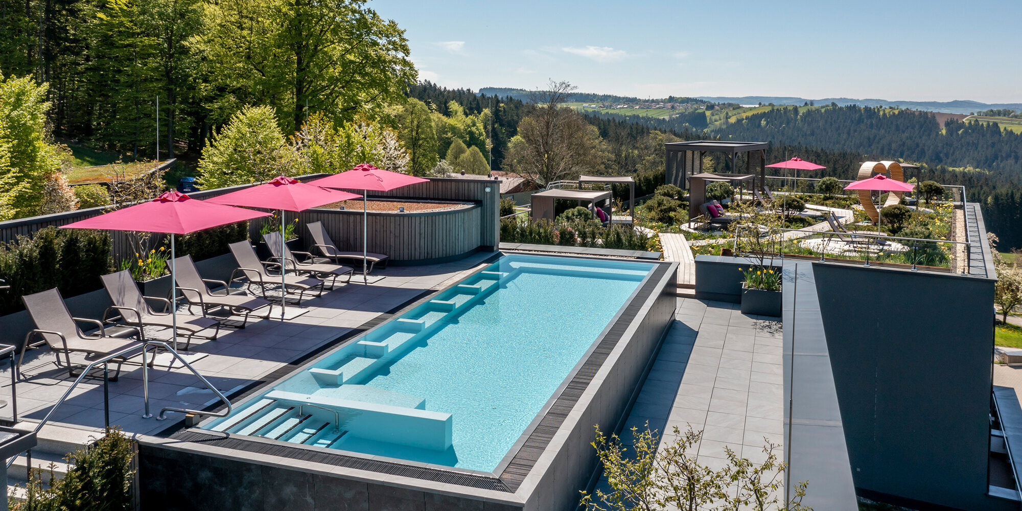 Liegen und Sonnenschirme auf dem Balkon des Hotel Hüttenhof Bayern