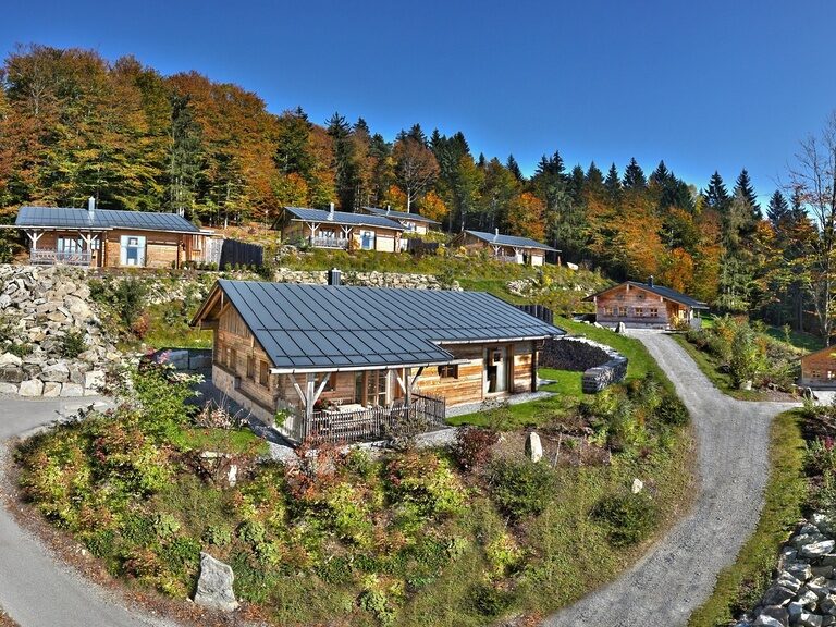 Frau fotografiert mit Handy den beleuchteten Innenpool im modernen 4-Sterne-Hotel Hüttenhof