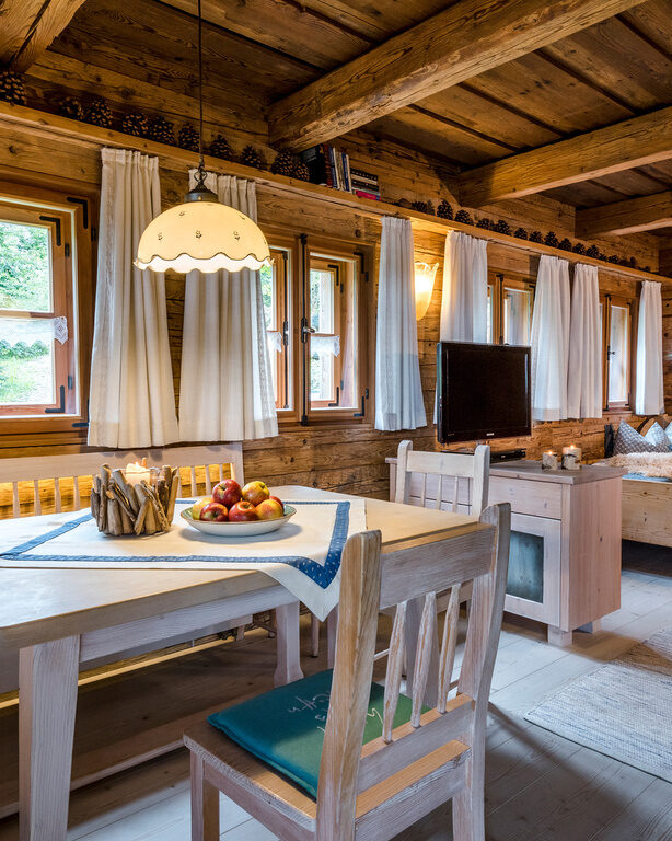 Wohnbereich mit Esstisch und Bett im Luxus Chalet Bayern im Bergdorf Hüttenhof