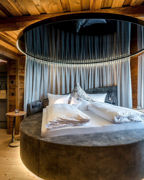 Schlafzimmer mit rundem Bett und freistehender Badewanne im Luxus Chalet Bayerischer Wald