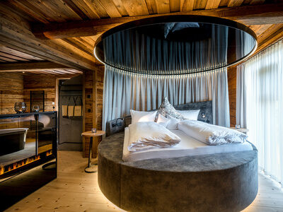 Schlafzimmer mit rundem Bett und freistehender Badewanne im Luxus Chalet Bayerischer Wald