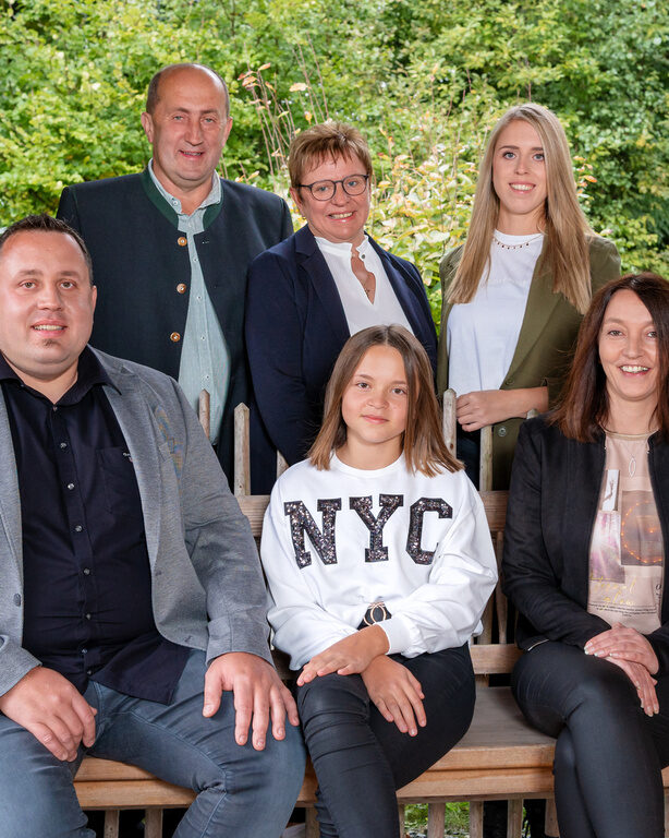 Familie Paster auf einer Bank in einem Chalet