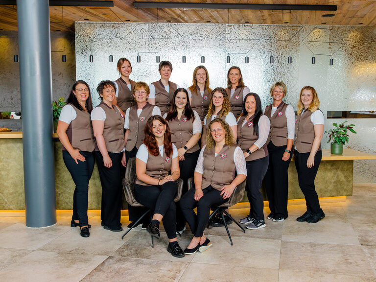 Rezeptionsteam in pinker Trachtenweste im Luxus-Wellnesshotel Hüttenhof