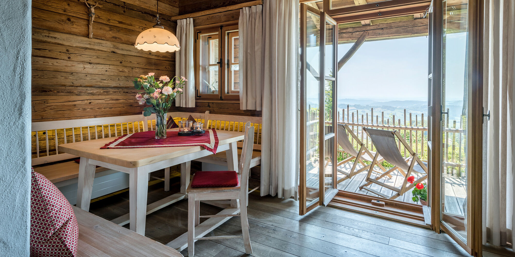 Essbereich im Luxus Chalet Bayern mit Blick auf die Terrasse und die einer traumhaften Aussicht