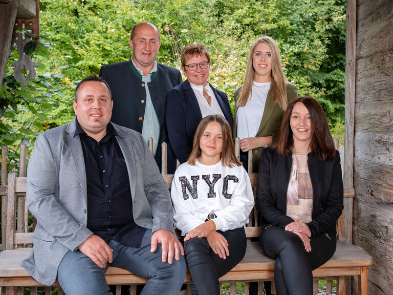 Familie Paster auf einer Bank in einem Chalet