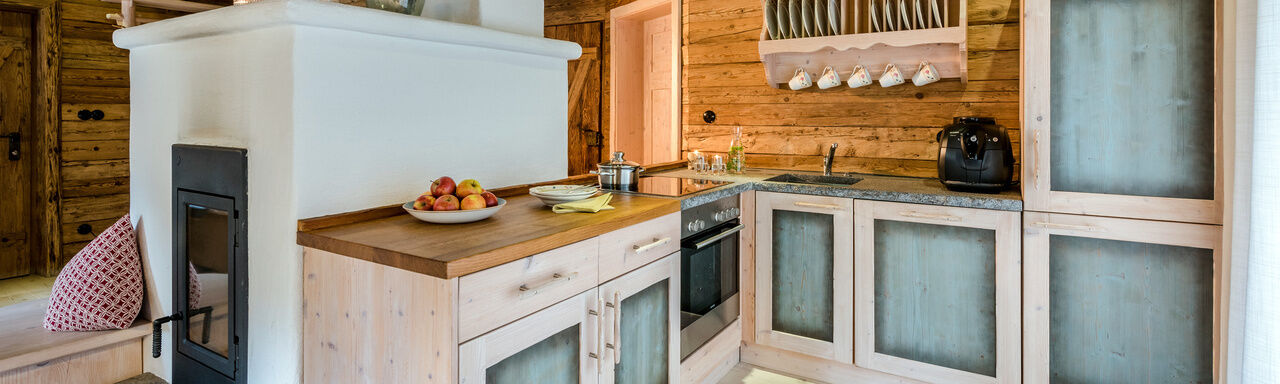 Küche mit Kachelofen im Luxus Chalet Bayern im Bergdorf Hüttenhof