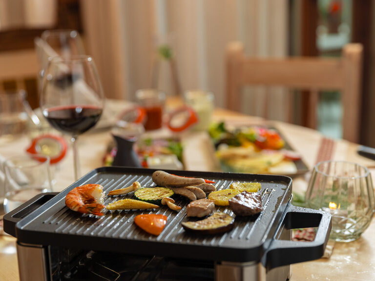 Lächelndes Paar genießt Panorama im Außenpool vom 4-Sterne-Luxushotel Hüttenhof