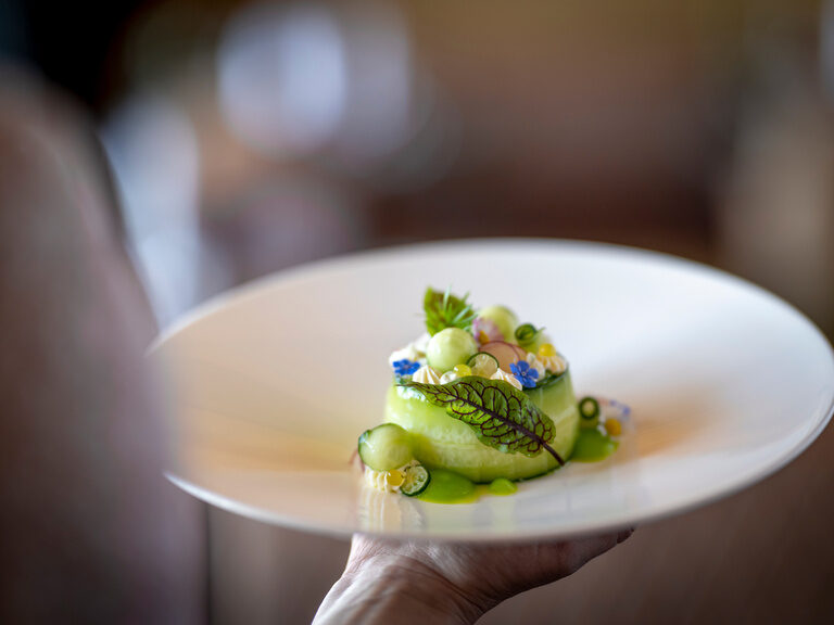 Lächelndes Paar genießt Panorama im Außenpool vom 4-Sterne-Luxushotel Hüttenhof