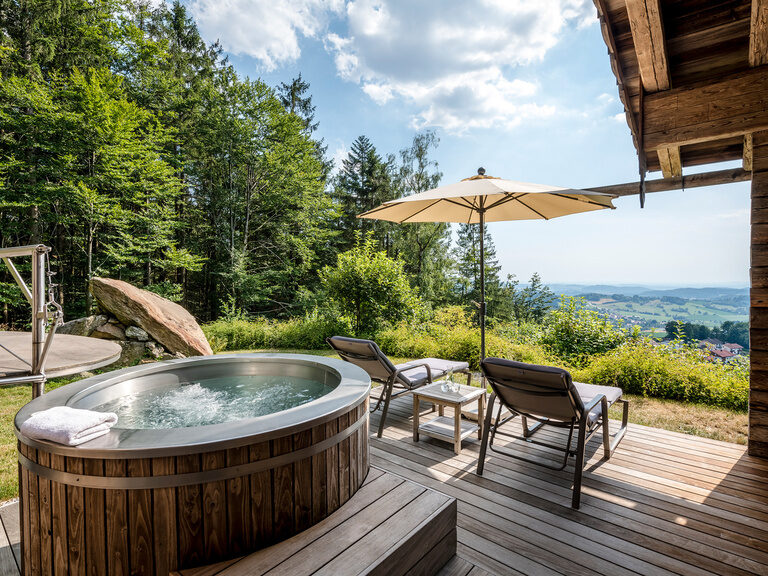 Moderne Luxussuite im Wellnesshotel Hüttenhof mit goldenem Kamin und großem Bett