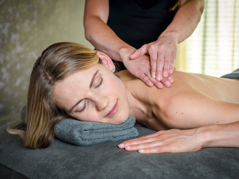 Paar liegt entspannt auf Liegen während einer Rückenmassage