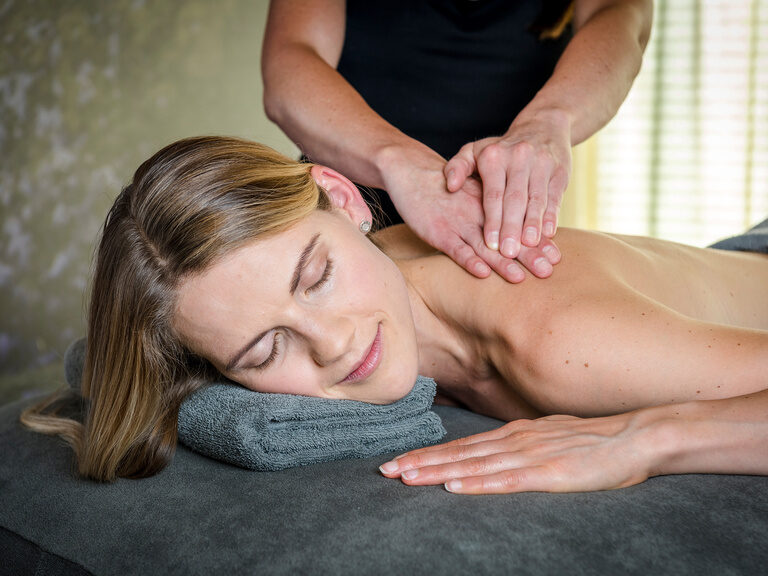 Paar liegt entspannt auf Liegen während einer Rückenmassage