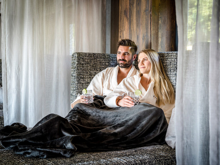 Pool auf sonniger Dachterrasse mit Sonnenschirmen und Waldpanorama vom Hotel Hüttenhof
