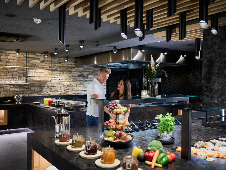 Pool auf sonniger Dachterrasse mit Sonnenschirmen und Waldpanorama vom Hotel Hüttenhof