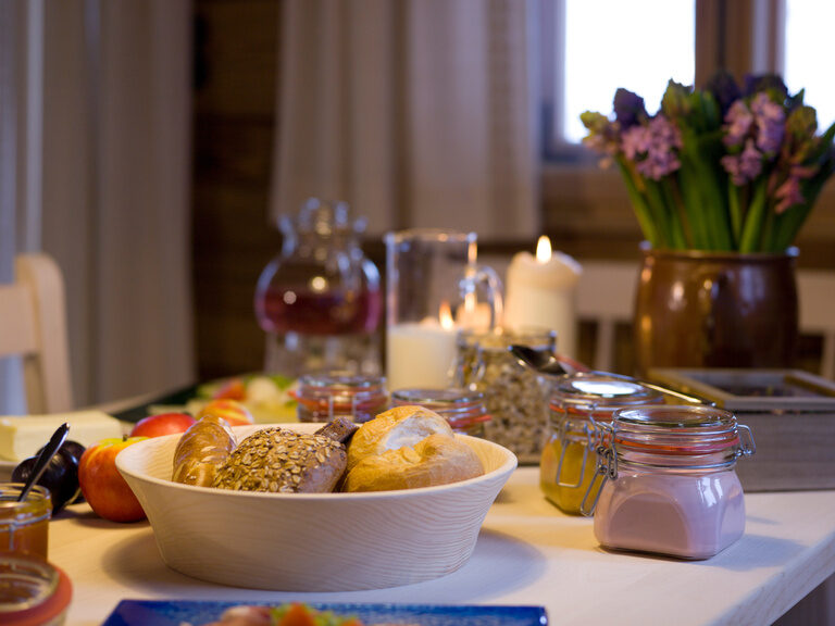 Pool auf sonniger Dachterrasse mit Sonnenschirmen und Waldpanorama vom Hotel Hüttenhof