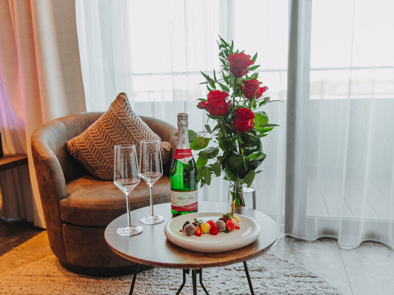 Herrlich angerichteter Pralinenteller mit zwei Gläser Sekt und roten Rosen des 4 Sterne Wellnesshotel Hüttenhof im Bayerischen Wald