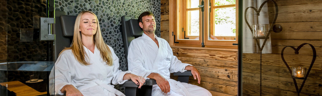 Pärchen sitz in der Sauna im Luxus Chalet Bayern