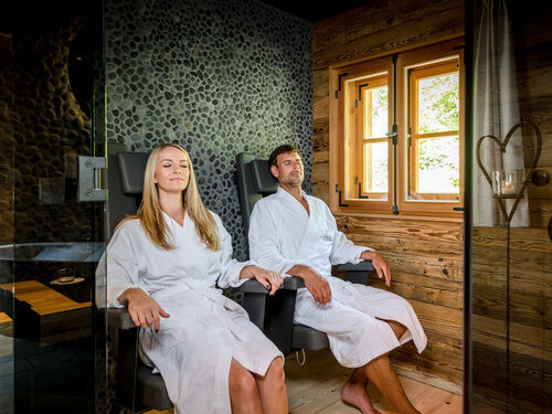 Pärchen sitz in der Sauna im Luxus Chalet Bayern