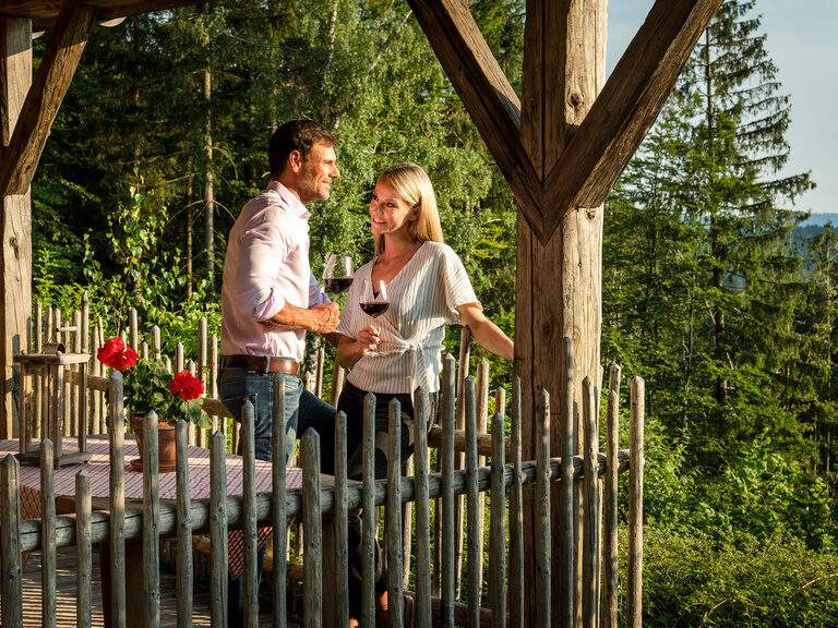 Paar stoßt lachend mit Sektgläsern an im Hotel Hüttenhof