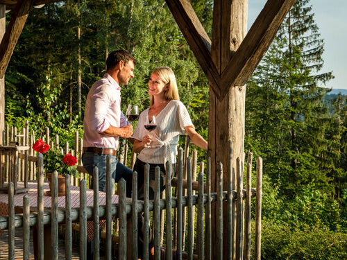 Pärchen genießt Wein auf Terrasse der exklusiven chalets Bayern