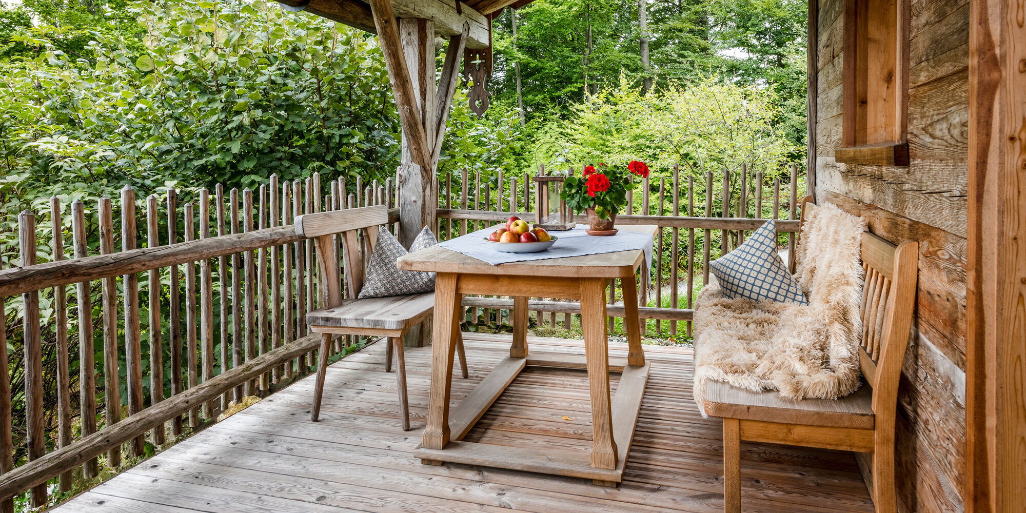 Terrasse mit Tisch und Bänken und Luxus Chalet Bayerischer Wald