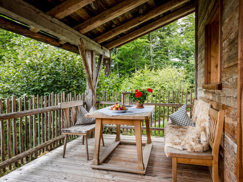 Terrasse mit Tisch und Bänken und Luxus Chalet Bayerischer Wald