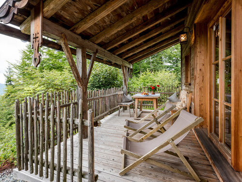 Terrasse mit Tisch, Bänken und Liegen im Luxus Chalet Bayerischer Wald