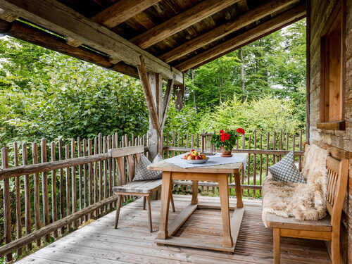 Terrasse mit Tisch und Bänken und Luxus Chalet Bayerischer Wald