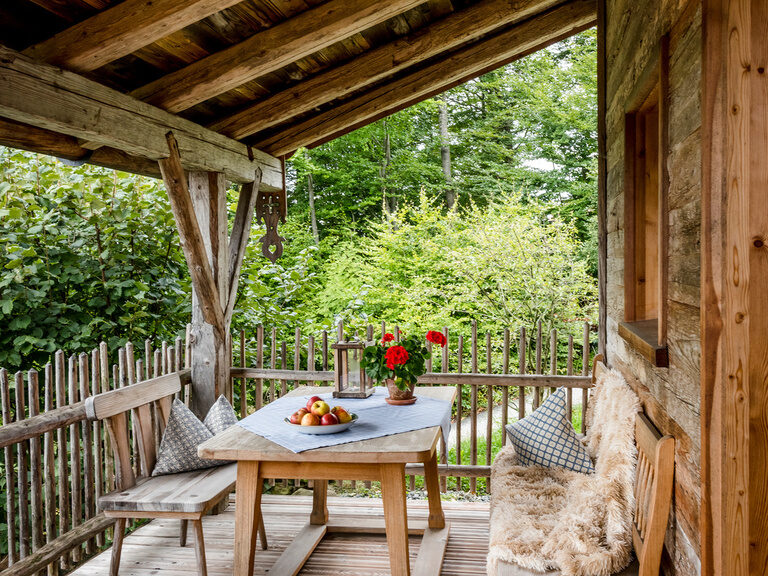 Terrasse mit Tisch und Bänken und Luxus Chalet Bayern