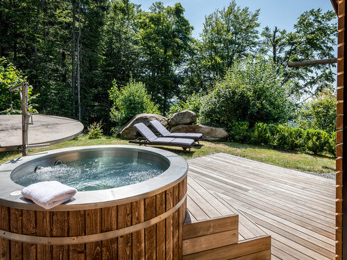 Terrasse mit Whirlpool und Liegen des Luxus Chalets Bayerischer Wald