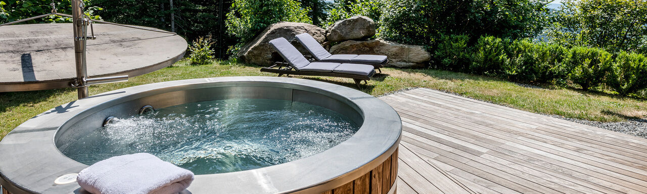Terrasse mit Whirlpool und Liegen des Luxus Chalets Bayern