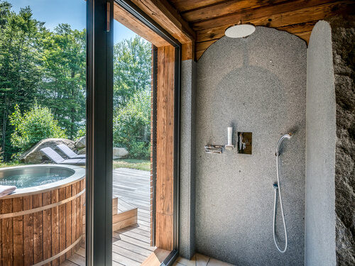 Dusche mit Blick auf die Terrasse mit Whirlpool des Luxus Chalets Bayern