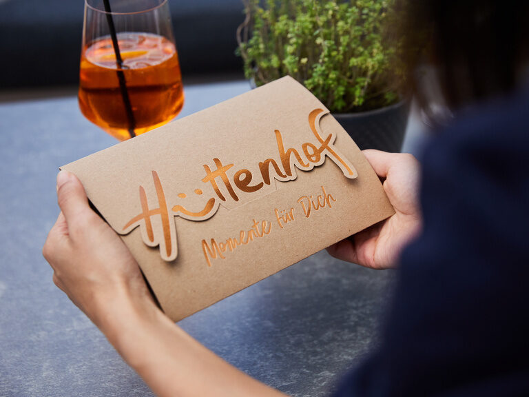 Gutschein des Wellnesshotel Hüttenhof mit goldener Aufschrift