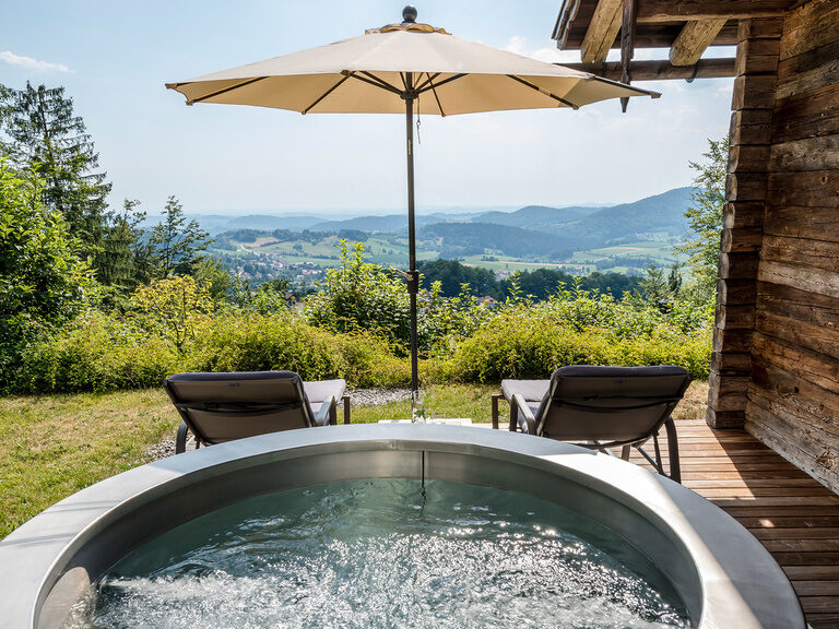 Whirlpool und Liegen auf der Terrasse des Luxus Chalets Bayern mit traumhafter Aussicht