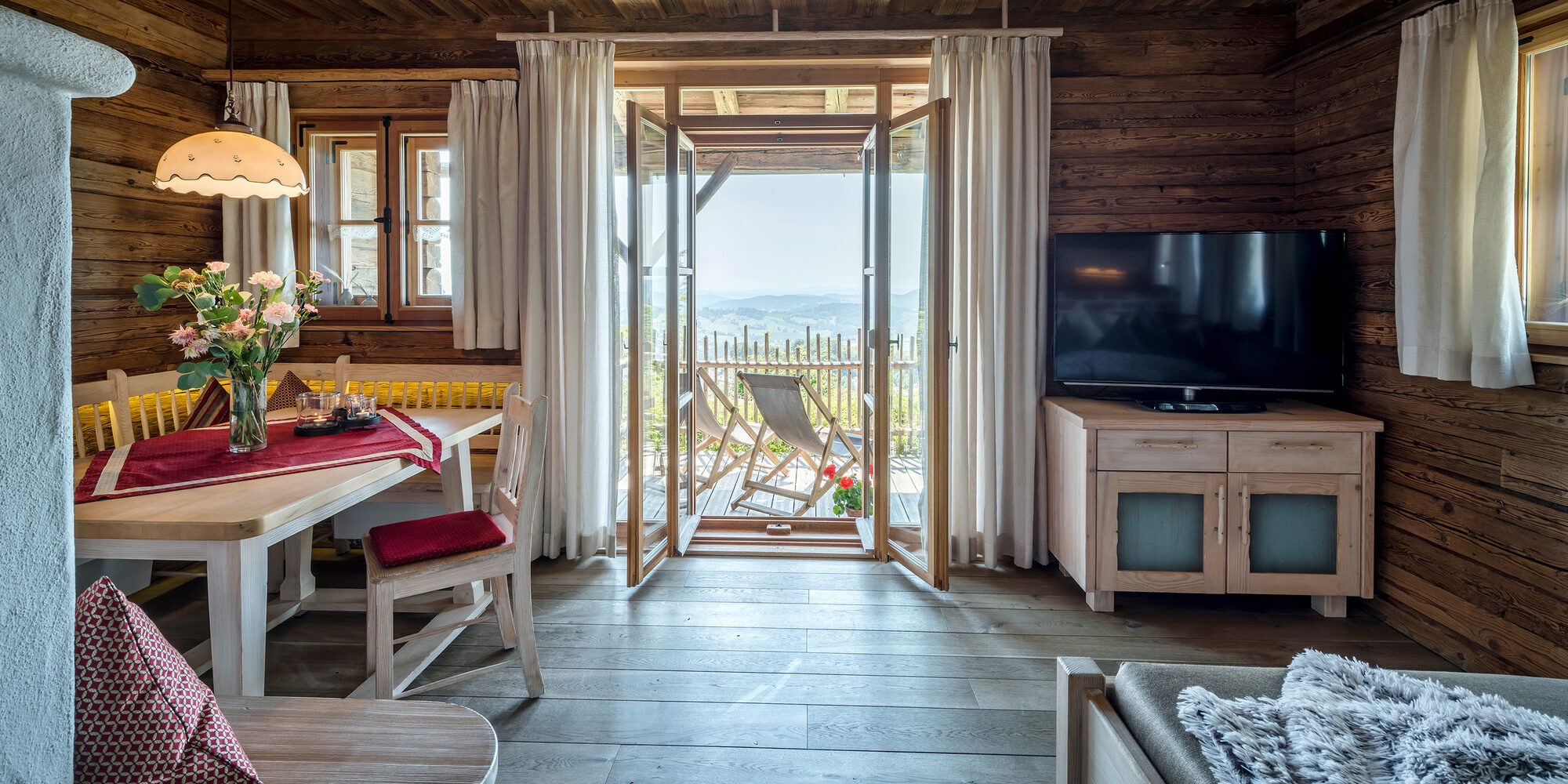 Wohnbereich im Luxus Chalet Bayerischer Wald mit Blick auf die Terrasse und die einer traumhaften Aussicht